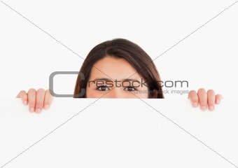 Lovely woman hiding behind a board