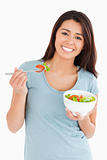 Good looking woman eating a bowl of salad