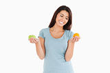 Beautiful woman holding an apple and an orange