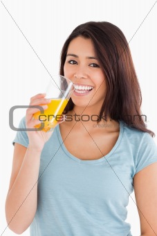 Beautiful woman drinking a glass of orange juice