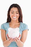 Pretty woman posing with a piggy bank