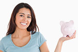 Lovely female holding a piggy bank