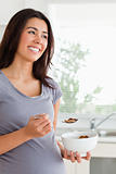 Attractive pregnant woman enjoying a bowl of cereal