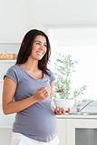 Beautiful pregnant woman enjoying a bowl of cereal