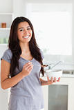 Pretty woman enjoying a bowl of cereals while standing