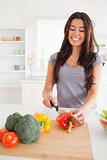 Good looking female cooking vegetables while standing