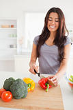 Charming female cooking vegetables while standing