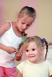 Small girl getting hair comb