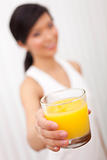 Asian Chinese Girl Holding Glass of Orange Juice to Camera