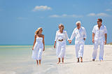 Two Couples Generations of Family Walking on Tropical Beach 