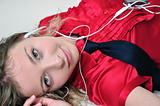 Attractive girl enjoying music laying