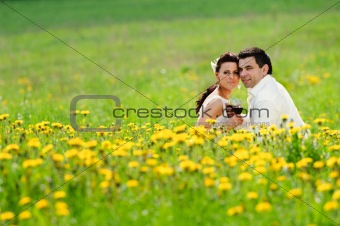 Bride and Groom drink a wine in the field of dandelion