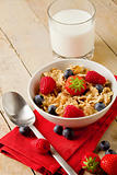 Corn flakes with berries on wooden table