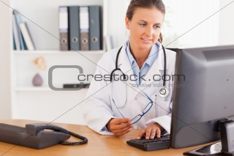 Serious female doctor working with a computer