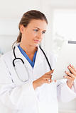 Charming doctor with  a stethoscope pointing at a file