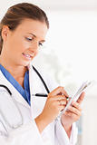 Close up of a brunette doctor writing something down