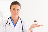 Portrait of a brunette doctor looking at some pills