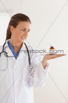 Good looking brunette doctor looking at some pills