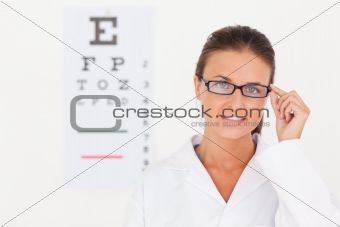 Brunette eye specialist wearing glasses looking into the camera