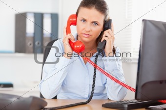 Secretary telephoning with two telephones