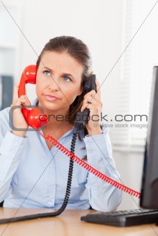Businesswoman telephoning with two telephones