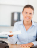 Smiling brunette businesswoman handing out a paper