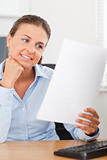 Charming businesswoman smiling at a paper