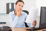 Charming businesswoman concentrating on a paper