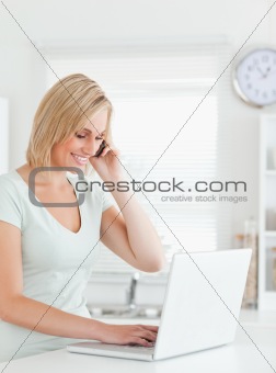 Blonde woman with a laptop and a phone