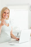 Charming woman with a cup of coffee and a laptop 