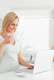 Charming woman with a cup of coffee and a laptop