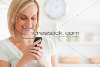 Close up of a cute woman smiling at her mobile