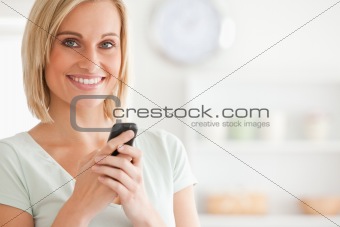 Close up of a cute woman with mobile looking into the camera