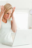 Upset woman looking at her laptop not knowing what to do