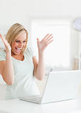 Laughing gorgeous woman looking at laptop