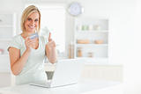 Blonde woman with credit card and notebook holding thumb up 