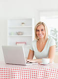 Smiling woman sitting at a table with cup of coffee and notebook