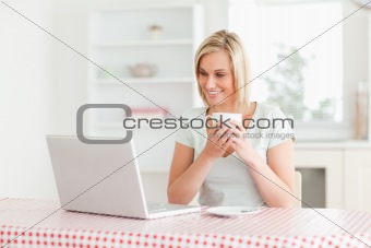 Woman holding coffee with laptop in front of her
