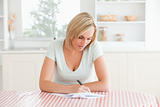 Woman sitting at a table writing a letter