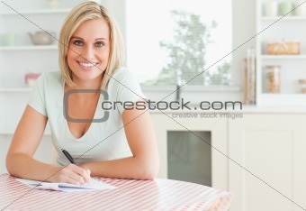 Charming woman proof-reading a text looks into camera