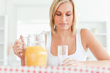 Close up of a woman sitting at a table with orange juice and gla