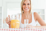 Close up of a woman sitting at a table with orange juice 