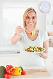 Smiling woman offering salad