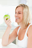 Young smiling woman watching a green apple