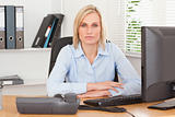 Serious woman sitting behind a desk