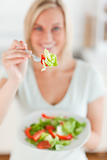 Smiling woman offering salad
