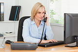 Smiling businesswoman on the phone looking at her screen