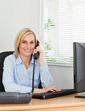 Smiling blonde businesswoman on the phone looking into camera