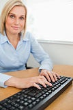 Typing woman looking into camera