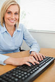 Smiling typing woman looking into camera